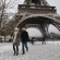 Ir a la foto Una pareja camina junto a la Torre Eiffel nevada
