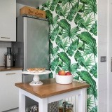 El papel pintado con motivos vegetales se hace un hueco importante en la cocina